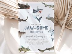 a birthday party card with sharks and shark fins on it, next to an open book