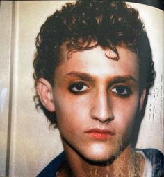 a young man with curly hair and blue eyes