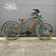 a green bike parked in front of a garage door next to a wall with a brown leather seat and handlebars