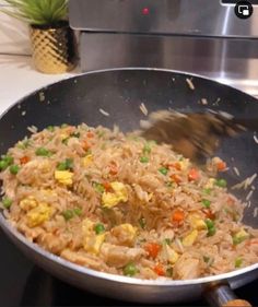 a pan filled with rice and vegetables on top of a stove