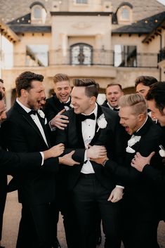 a group of men in tuxedos standing next to each other with their mouths open