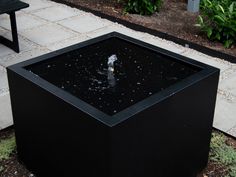 a black box with water in it sitting on the ground