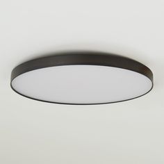 a round light fixture on a white wall