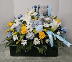 a blue and yellow flower arrangement with an elephant