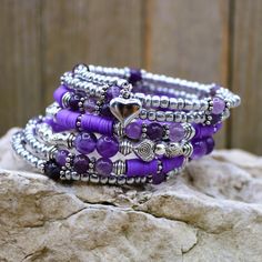 "This beautiful February Birthstone seven layer healing stone bracelet is a truly unique statement piece. The Amethyst and silver beads give that sweet and soft romantic vibe which wears well for many occasions from weekend wear to dressy wedding. The perfect gift as the one-size-fits-all feature makesgifting easy! . Made with memory wire, a kind of wire that never loses its shape. You simply wrap the bracelet around your wrist. The bracelet coils wrap around the wrist and gives the impression o Adjustable Silver Wrap Bracelet With Gemstone Beads, Silver Amethyst Beaded Bracelets For Meditation, Purple Spiritual Beaded Bracelets For Festivals, Spiritual Purple Beaded Bracelets For Festivals, Silver Gemstone Bead Bracelets For Festivals, Silver Gemstone Beads Wrap Bracelet As Gift, Silver Gemstone Beaded Wrap Bracelet As Gift, Silver Wrap Bracelet With Gemstone Beads For Gift, Silver Gemstone Beads Wrap Bracelet