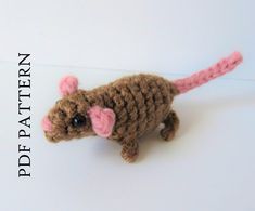 a small crocheted rat sitting on top of a white surface with the words pattern written below it