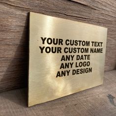 a metal sign that says your custom text is on the side of a wooden wall