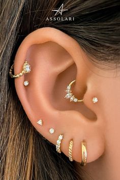 an ear with three different types of piercings on it's side, and one is