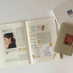 an open book with pictures on it next to a pen and paper clippings