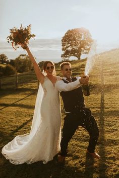 a bride and groom pose for a photo in front of the sun on their wedding day