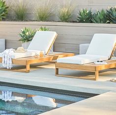 three lounge chairs sitting next to a pool