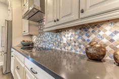 a kitchen with stainless steel counter tops and white cabinets