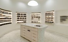 a room filled with lots of bottles and shelves next to a counter topped with drawers