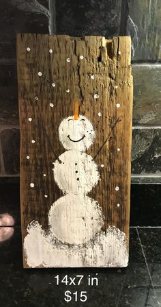 a wooden sign with a snowman painted on it