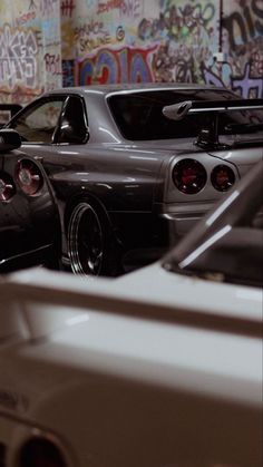 several cars parked in a parking garage with graffiti on the walls