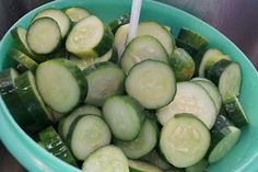 a bowl filled with sliced cucumbers on top of a table