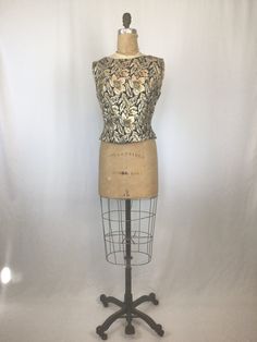 "Vintage 1950s floral brocade evening top Fabric is a metallic floral print on black brocade Bateau neckline Sleeveless Bust darts Fitted at waist Fully lined Pull On with no closures (will need measurements slightly bigger then your actual to slip on over head) Measurements Fits Like XSmall Measured flat Shoulders: 15\" Bust: 36\" Waist: 30\" Sleeve opening: 8.5\" diameter Length: 17.5\" from top of shoulder Label/Brand: None Condition: Excellent *lipstick stain on lining (see pic) Stay in touc Vintage Sleeveless Top With Boned Bodice, Vintage Sleeveless Printed Tops, Fitted Gold Brocade Tops, 1950s Short Sleeve Cotton Tops, 1950s Brocade Dress, Evening Tops, Lace Shift Dress, Bateau Neckline, Vintage Wardrobe