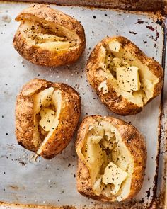 four pieces of bread that have been baked on a baking sheet with butter and seasoning