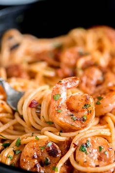 pasta with shrimp and parmesan cheese in a skillet being held by a fork