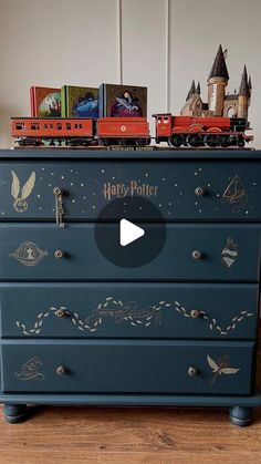 a blue dresser with harry potter decorations on it and a toy train sitting on top