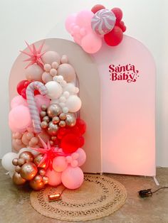 a bunch of balloons that are in front of a sign with the name santa baby on it