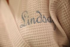 the word sindbay is written in blue ink on a white robe that's folded over