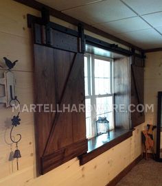 an empty room with wooden shutters and a bird cage on the window sill