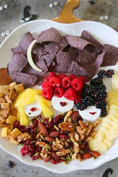 a white plate topped with different types of snacks and fruit on top of each other