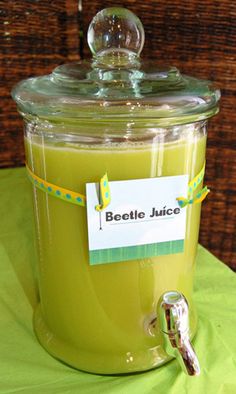 a glass jar filled with liquid sitting on top of a green tablecloth covered table