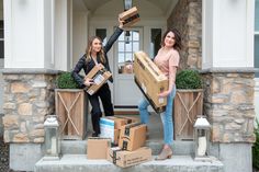 two women are holding boxes on the front steps