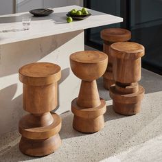 four wooden stools sitting in front of a counter