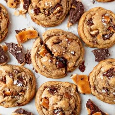 chocolate chip cookies with peanut butter and sea salt on top, lined up on a sheet of parchment paper