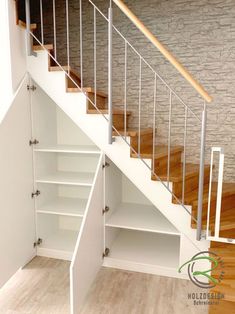 an empty room with some shelves under the stairs