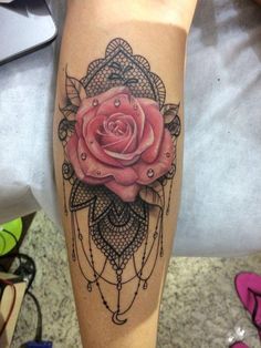 a pink rose tattoo on the leg