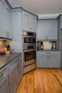 a kitchen with stainless steel appliances and wood flooring is pictured in this image, it appears to be empty