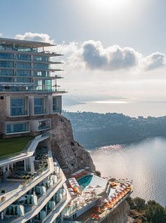 an aerial view of a hotel on the edge of a cliff overlooking a body of water