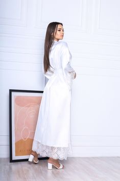 This white long robe is made of high-qualiry silk satin. It has long wide sleeves made of lace and wide belt. When you have one of the most important days in your life, everything should be perfect! You probably planned every minute of this day and now you are ready to make it real. The perfect day starts from the very morning which will be remembered every time you will look at your photos. The bride robe should be beautiful and comfortable at the same time so you could enjoy this day in full! Elegant Satin Kimono For Wedding Night, Long Satin Robe For Wedding Night, Long Wedding Robe With Satin Finish, Long Satin Gown For Wedding Night, Cream Satin Robe For Wedding Night, Elegant Long Sleeve Robe For Bridal Shower, White Long Sleeve Robe For Bridal Shower, White Long Gown With Lace Trim, Elegant Long Kimono With Lace Trim