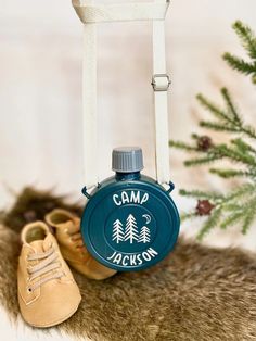 a camping flask hanging from the side of a christmas tree with shoes on it