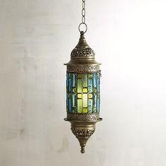 a hanging lamp with blue, green and yellow stained glass in an antique style setting