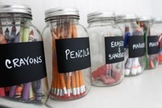 three glass jars filled with pencils and erasers