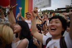 a group of people standing next to each other with their hands up in the air