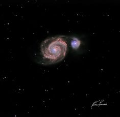 two spiral shaped objects in the dark sky