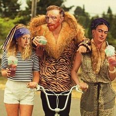 three women on bicycles with one dressed as a man and the other as a woman