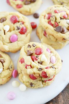 chocolate chip cookies with m & m's and candy canes on a white plate