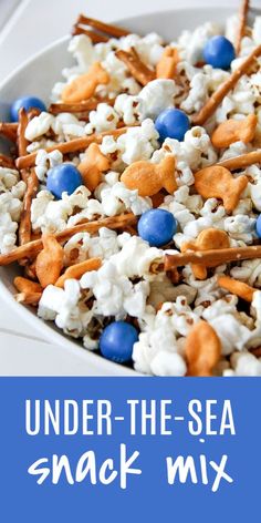 a white bowl filled with popcorn and blueberries next to the words under - the - sea snack mix