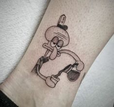 a cartoon character tattoo on the leg of a person's foot, with an eyeball in it