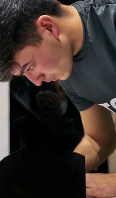 a man looking down at his laptop computer