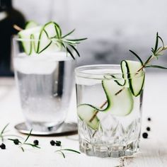 two glasses filled with water and cucumber slices