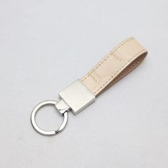 a white leather keychain with a metal ring