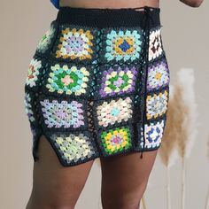 a crocheted skirt with multicolored squares on the bottom and sides, as seen from behind